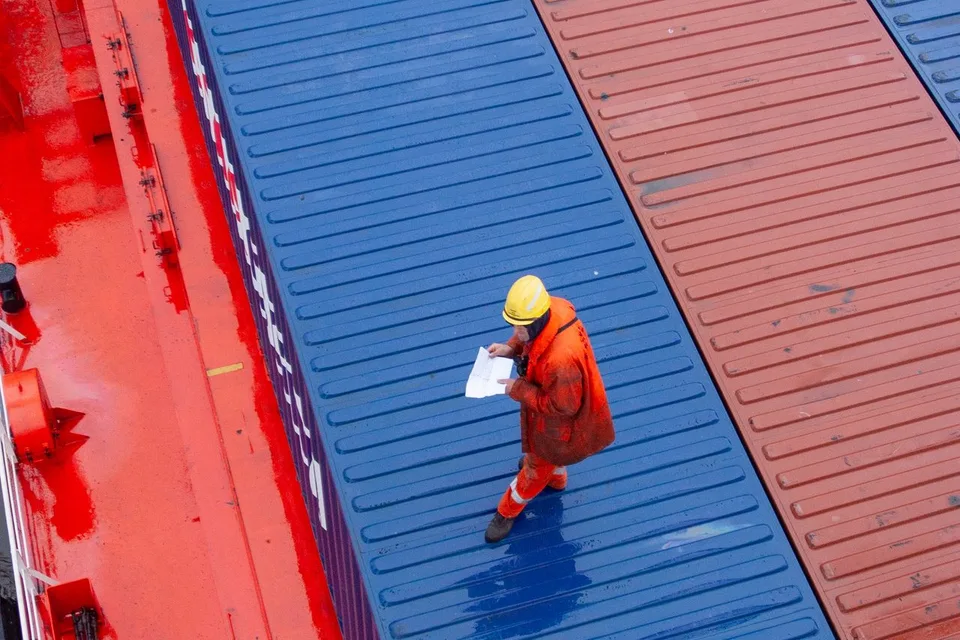 Staff overseeing containers and documentation during an international trade operation